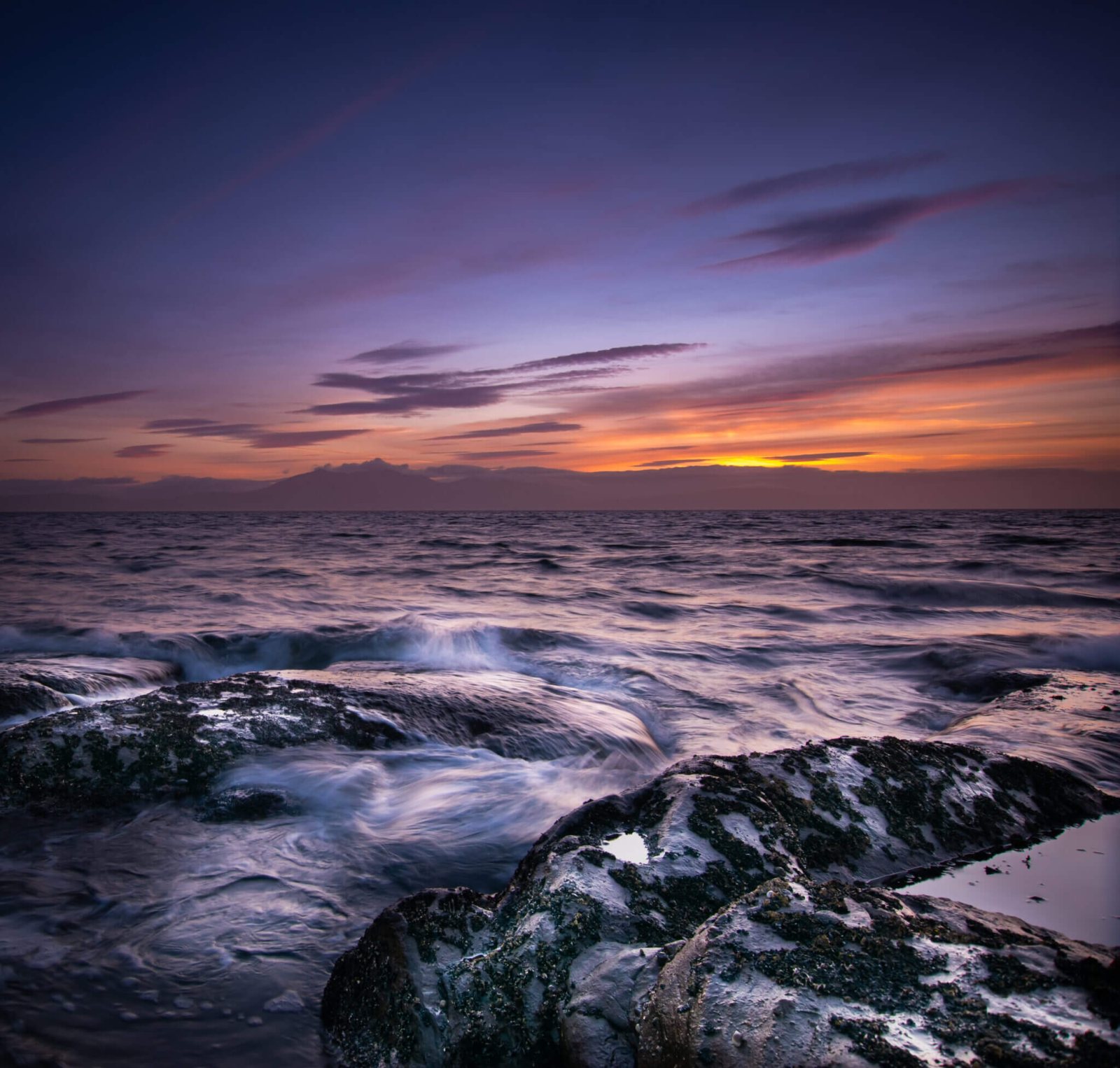A rocky shore at sunset, photographed by David Barco