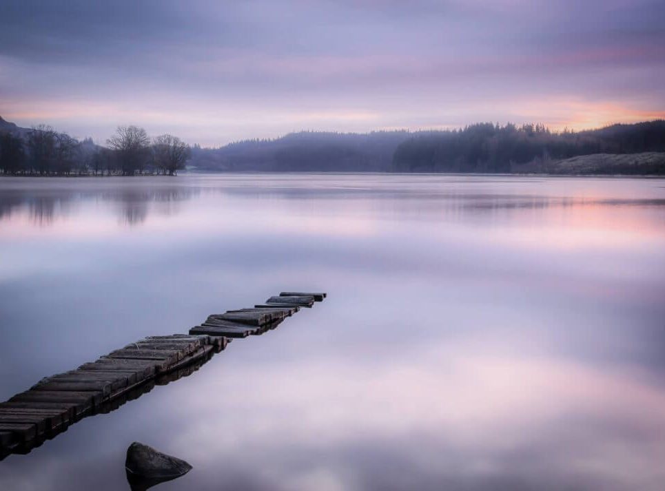 A small jetty on a calm loch, photographed by David Barco