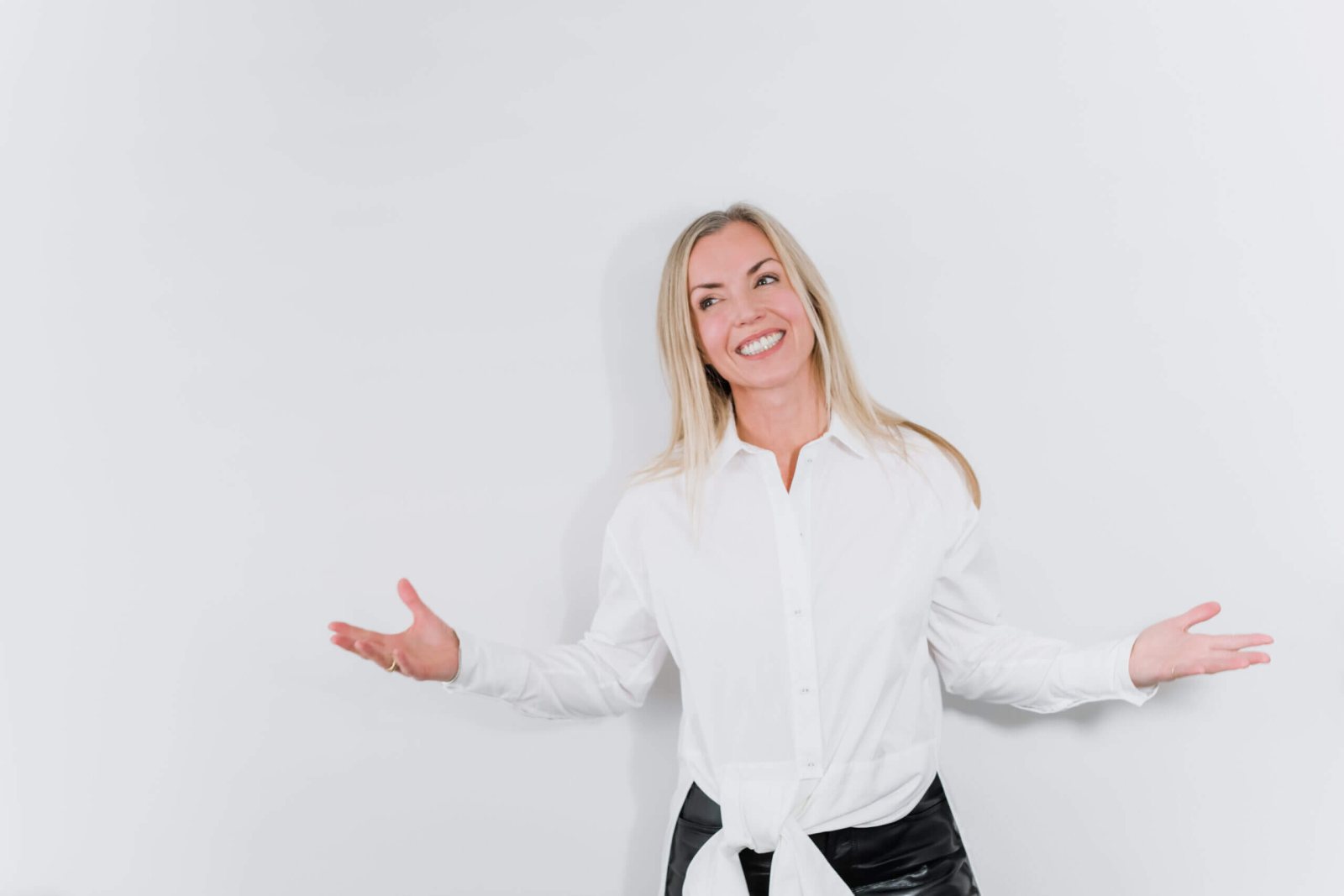 Nicole Bremner smiling with her arms open