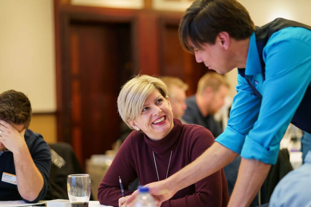 Steve leading a workshop, talking with a participant at her table